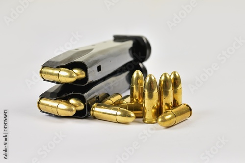 A semi-automatic pistol magazine loaded with several bullets on a white background