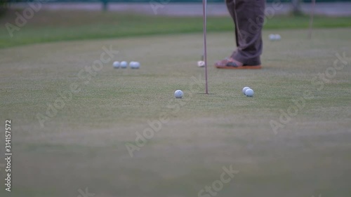 golfer putting golf ball in to the hole