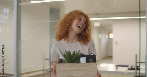 Happy young woman getting promotion and leaving office with things in box. Smilling office workers gratulating female coworker who moving up career ladder. Concept of work,career, success. photo