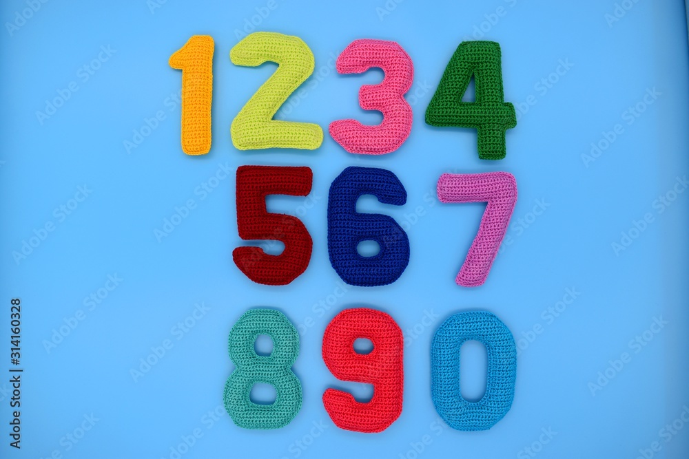 Naklejka premium 1, 2, 3, 4, 5, 6, 7, 8, 9, 0. Multicolored numbers on a blue background are knitted from yarn.