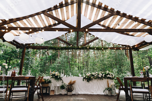 Canvastavla Bride and groom table decorated with flowers and lights in stylish boho wedding