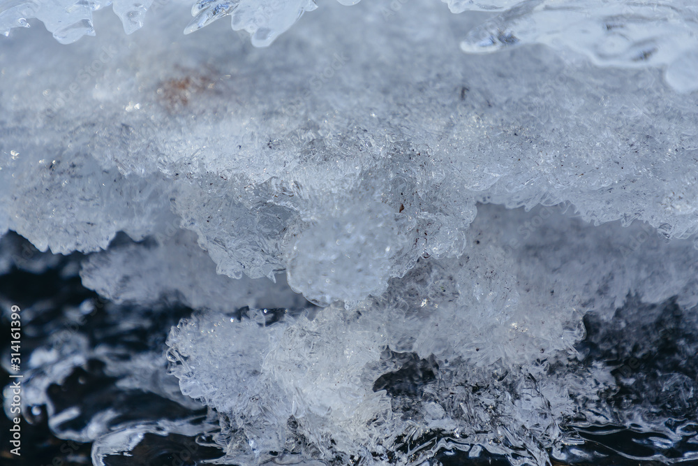 Obraz premium Ice texture, interesting frozen lake patterns, naturally created forms. Frozen river's water in the winter in mount Vitosha, near Sofia, Bulgaria. Ice Age climate changes.