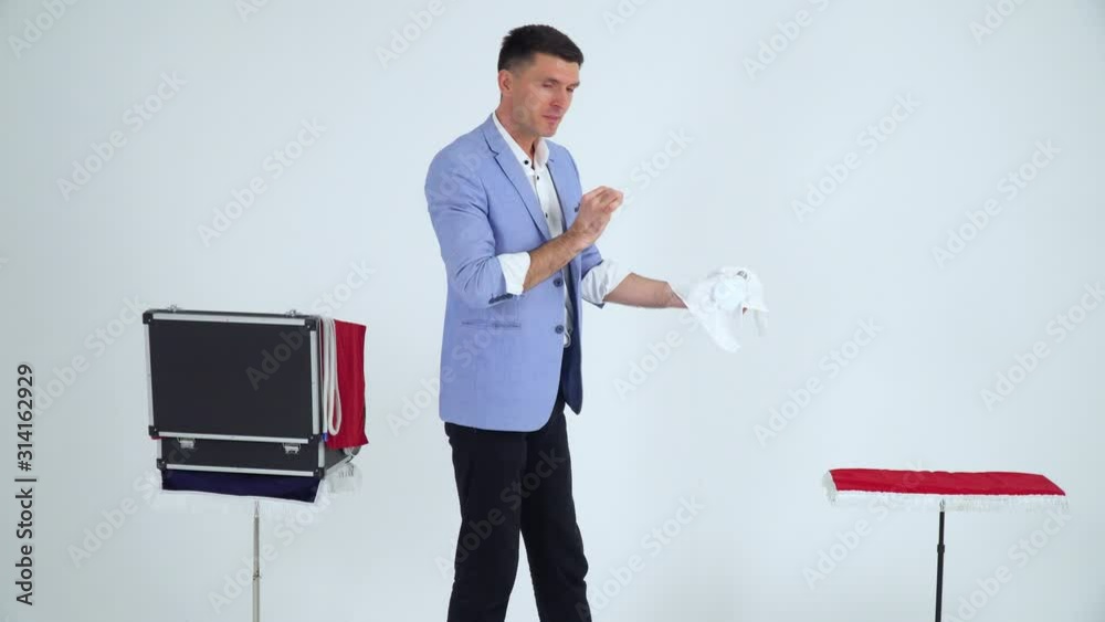 Magician in a suit shows a trick with lamp on a white background