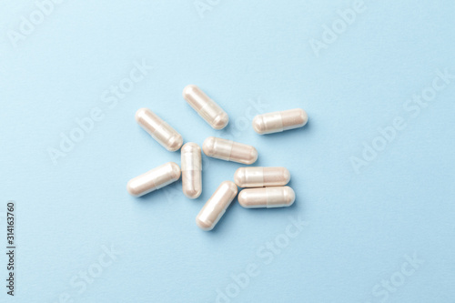Carnitine capsules. Concept for a healthy dietary supplementation. Bright paper background. Close up. Top view. 