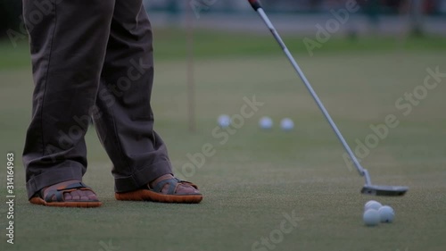 golfer putting golf ball in to the hole