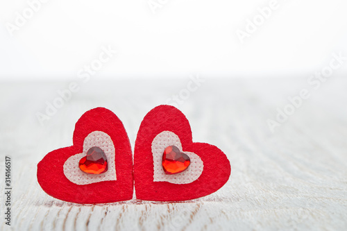 Two decorative hearts on  light wooden background. Valentine s Day card.