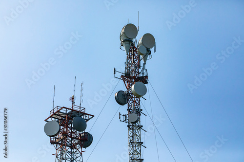 Telecommunication and mobile network infrastructure with two cell site towers side by side, housing antennas and Remote Radio Head, RRH, for greater coverage photo