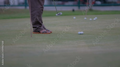 golfer putting golf ball in to the hole