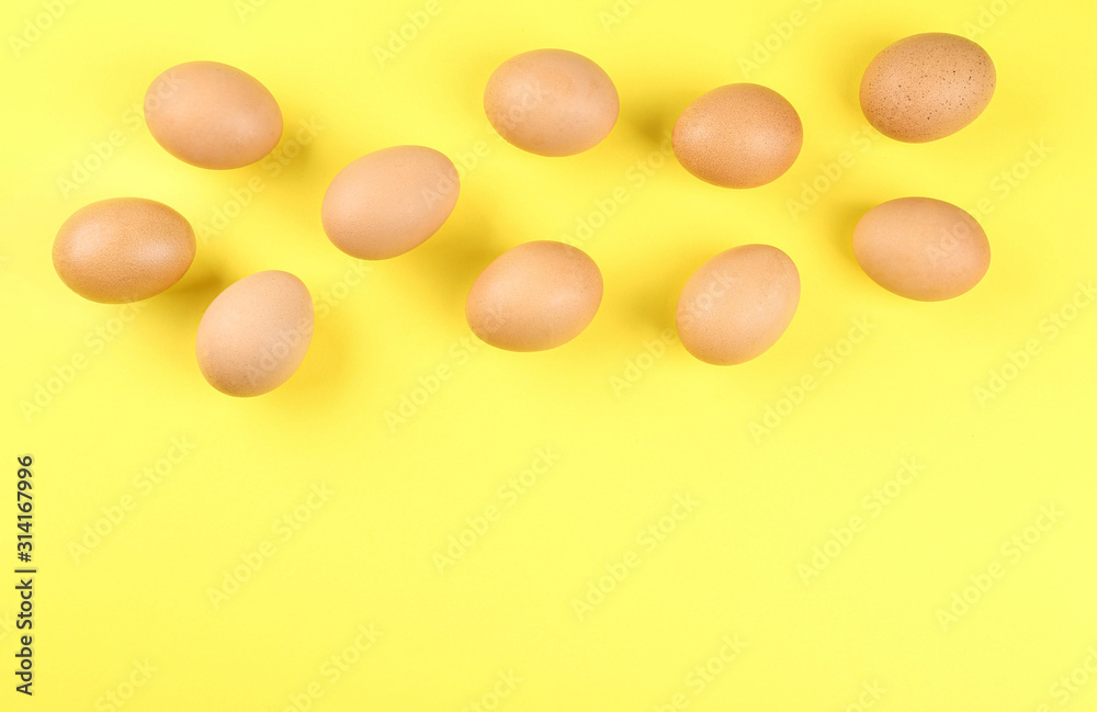 Raw chicken eggs on yellow background, flat lay. Space for text
