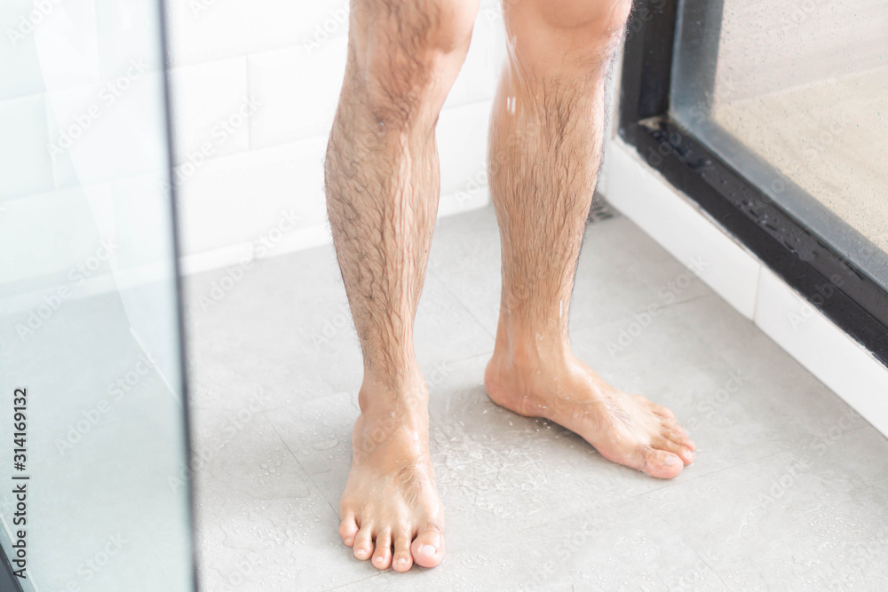 Close up man legs with taking a shower in the bathroom, health care Close up man legs with taking a shower in the bathroom, health care