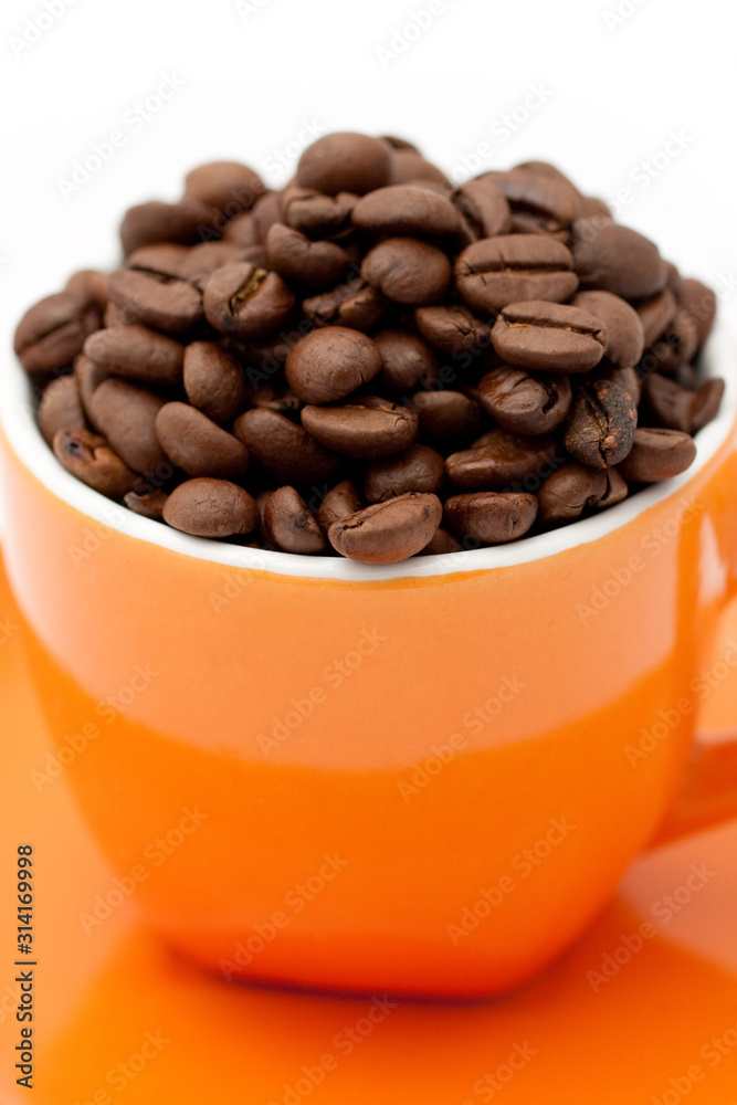 Roasted coffee beans in an orange cup Roasted coffee beans in an orange cup