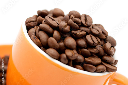 Roasted coffee beans in an orange cup