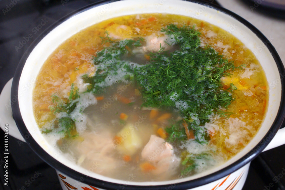 home-made soup is cooked on the stove, top view. the first dish with herbs and vegetables.