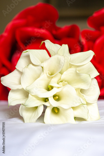 white calla Lilies bouquet with red roses background