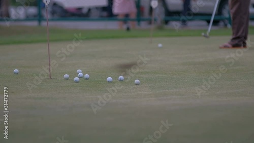 golfer putting golf ball in to the hole