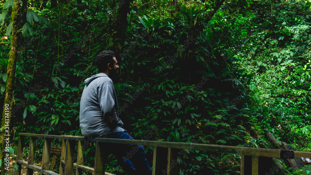 Man enjoying and relaxing in the forest sitting in the wood Man enjoying and relaxing in the forest sitting in the wood
