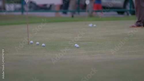 golfer putting golf ball in to the hole