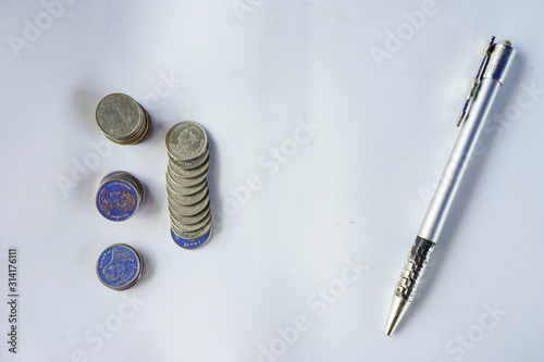 saving coin on the green tree White background with one pen
