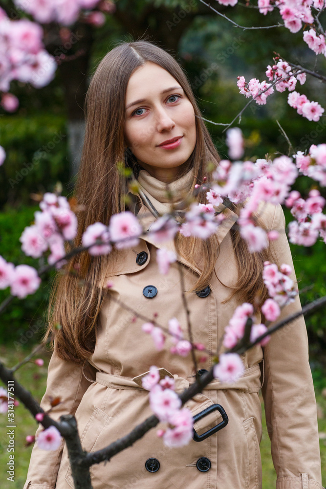 Fototapeta premium Portrait of beautiful woman with blooming flowers