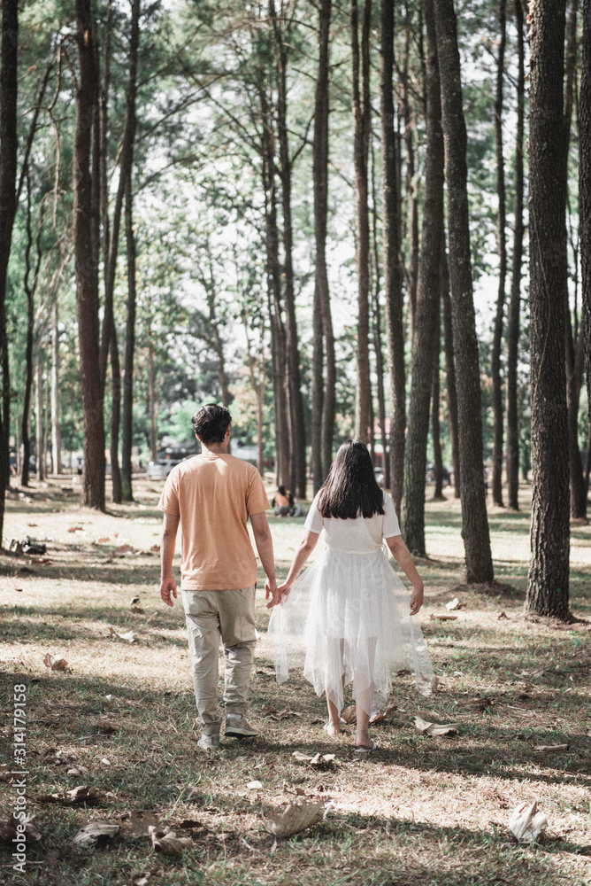 Fototapeta premium Pregnant woman and Husband posing outdoors.
