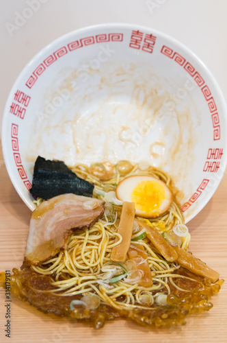 Japanese Spilled Ramen. Bowl of noodles, egg, and pork spilling out of a bowl onto the table. Example of plastic food model famous in Japan. 