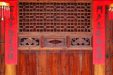 The old traditional style wood carving door with Spring festival couplets during Chinese new year.The text on scrolls means Hundreds of flowers in bloom in springtime and Good luck will come to home