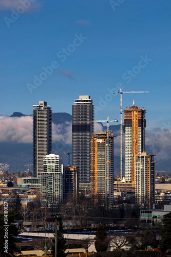  New construction of high-rise buildings in the city of Burnaby construction site in the center of the city against the backdrop of a mountain ridge