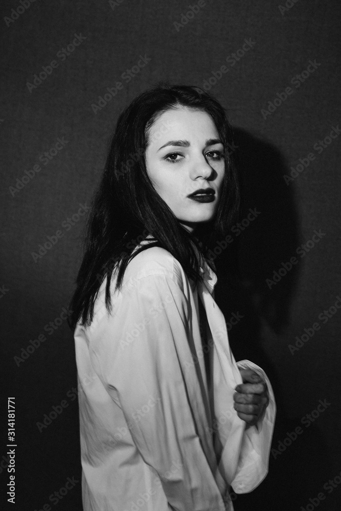 fashion portrait of Caucasian brunette girl posing in white shirt in Studio fashion portrait of Caucasian brunette girl posing in white shirt in Studio