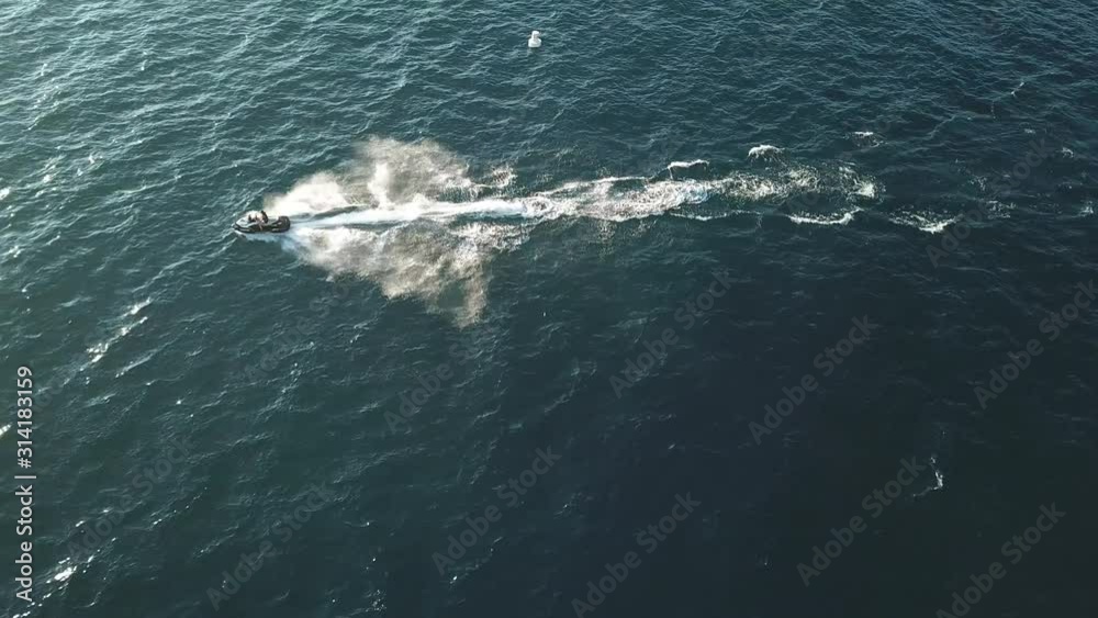 Jet Ski Scooter Personal Watercraft Sailing on Blue Lake Water on Sunny Day, Drone Aerial View Jet Ski Scooter Personal Watercraft Sailing on Blue Lake Water on Sunny Day, Drone Aerial View