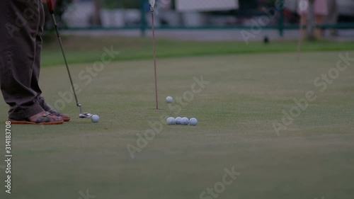 golfer putting golf ball in to the hole