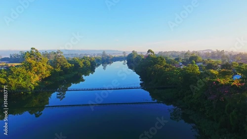 Drone Flying Over a River and a Rustic Bridge photo