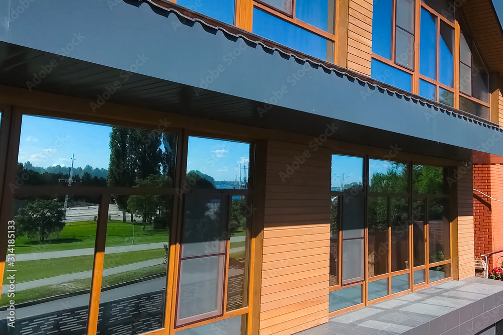 House with a gray metal roof and large windows on the facade. Co House with a gray metal roof and large windows on the facade. Co