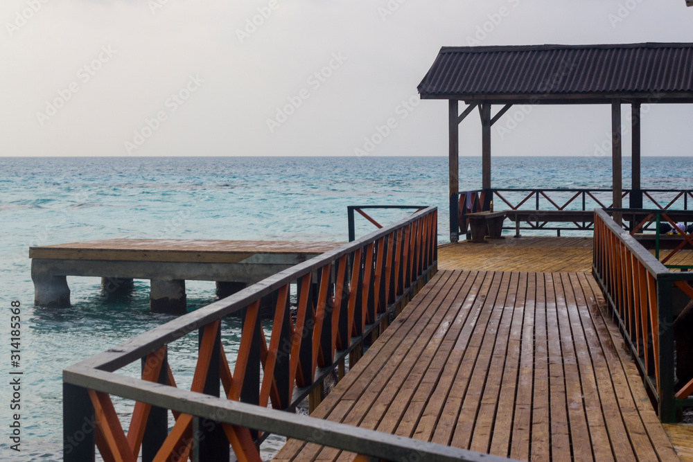 a wooden pier and the blue sea.