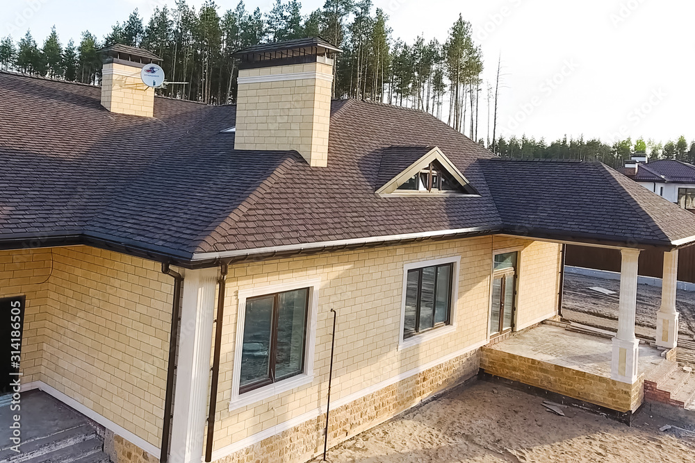Bituminous tile for a roof. House with a roof from a bituminous Bituminous tile for a roof. House with a roof from a bituminous