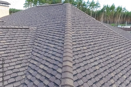 Bituminous tile for a roof. House with a roof from a bituminous photo