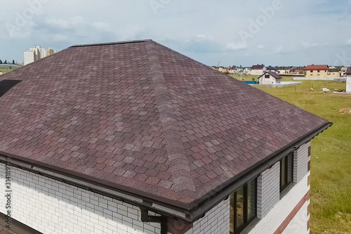 Bituminous tile for a roof. House with a roof from a bituminous photo