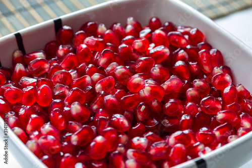 red ripe delicious juicy pomegranate seeds in a plate