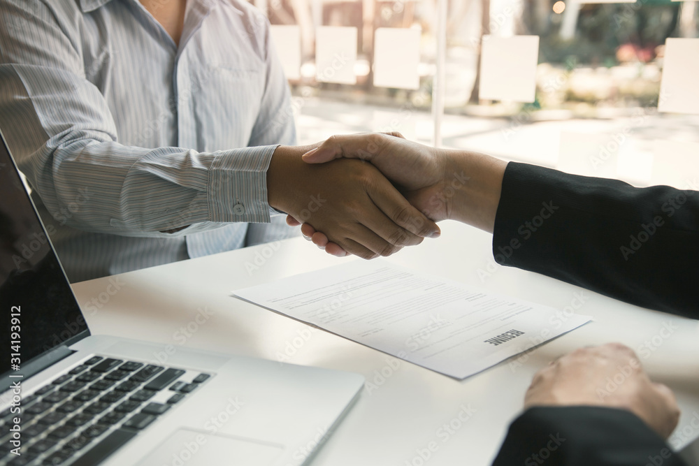 Manager and employee interview concept with handshake after talking about contract signing. Manager and employee interview concept with handshake after talking about contract signing.