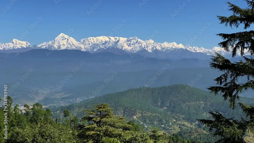 Steady cam , Slow motion, camera panning across the Himalayan Range of Kausani in Uttarakhand, India. Snow capped Mountains, and valley and range of mountains. Steady cam , Slow motion, camera panning across the Himalayan Range of Kausani in Uttarakhand, India. Snow capped Mountains, and valley and range of mountains.