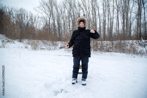 a man with a fishing rod in his hands on a winter fishing