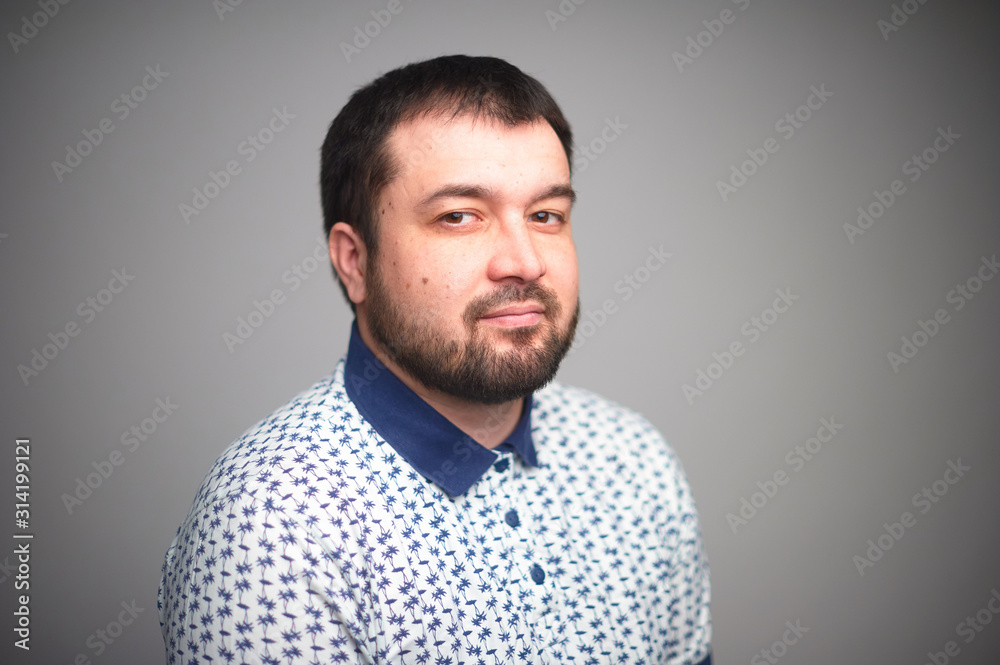Portrait of a happy white man carefully looking at the viewer, on a gray background Portrait of a happy white man carefully looking at the viewer, on a gray background