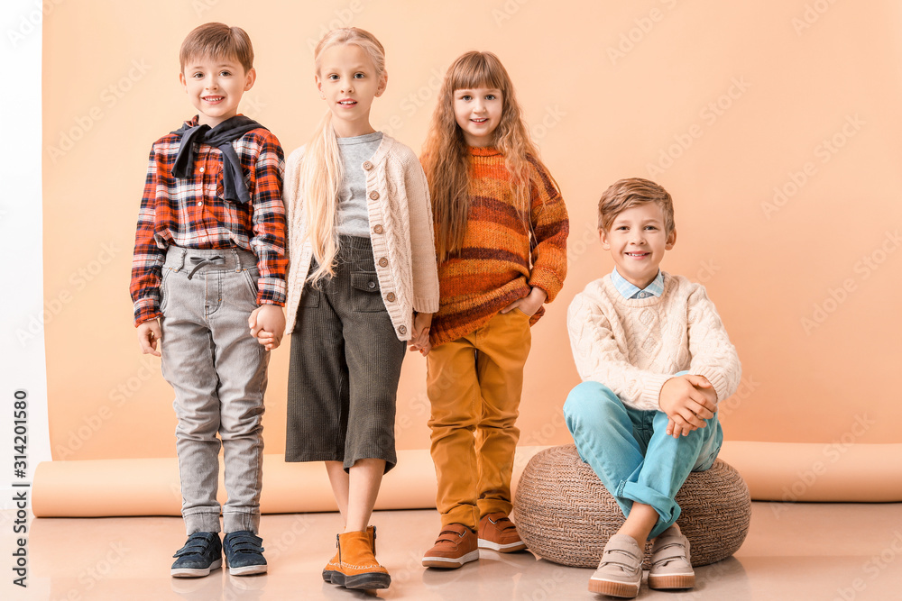 Cute Little Children In Autumn Clothes Near Color Wall Stock Photo 