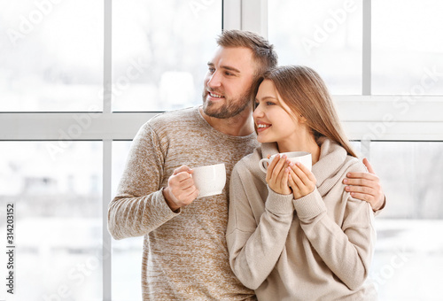 Happy couple with cups of h...