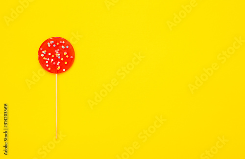 A large red Lollipop, on a yellow background. Minimal concept with copy space.
