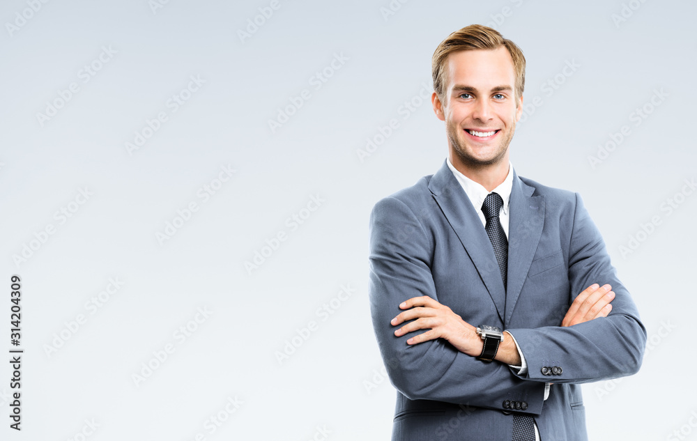 Portrait of happy smiling young businessman in grey confident suit, with copy space for some slogan or text. Business success concept. Portrait of happy smiling young businessman in grey confident suit, with copy space for some slogan or text. Business success concept.