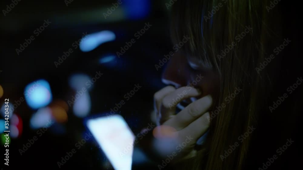 white woman seated in car wipes tear, close up
