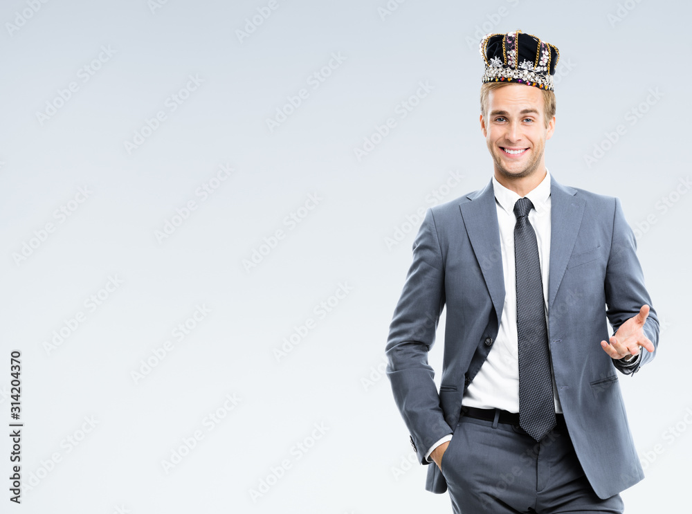 I am business king! Portrait of happy smiling young businessman in grey confident suit and crown, with copy space for some slogan or text. Leadership and business success concept. I am business king! Portrait of happy smiling young businessman in grey confident suit and crown, with copy space for some slogan or text. Leadership and business success concept.