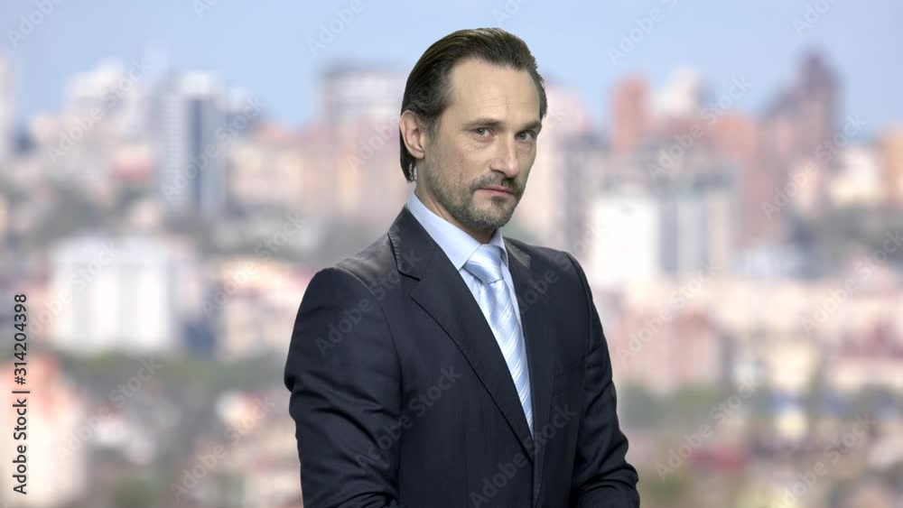Elegant entrepreneur is expressing mistrust. Doubtful caucasian businessman looking with disbelief expression. Blur city background. Elegant entrepreneur is expressing mistrust. Doubtful caucasian businessman looking with disbelief expression. Blur city background.