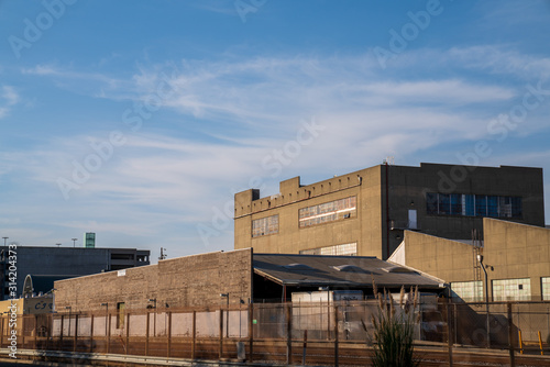 Grey industrial warehouse area behind fenced off railroad tracks