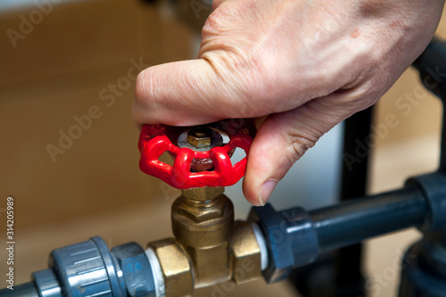 Hand spins valve close-up photo